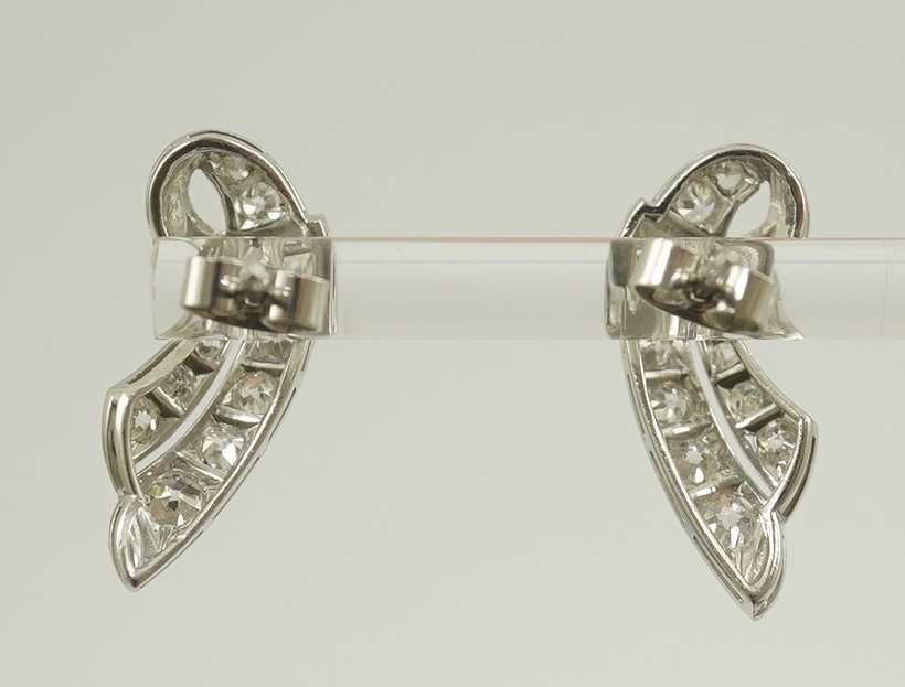 A pair of 18ct white gold and millegrain set diamond cluster scroll earrings